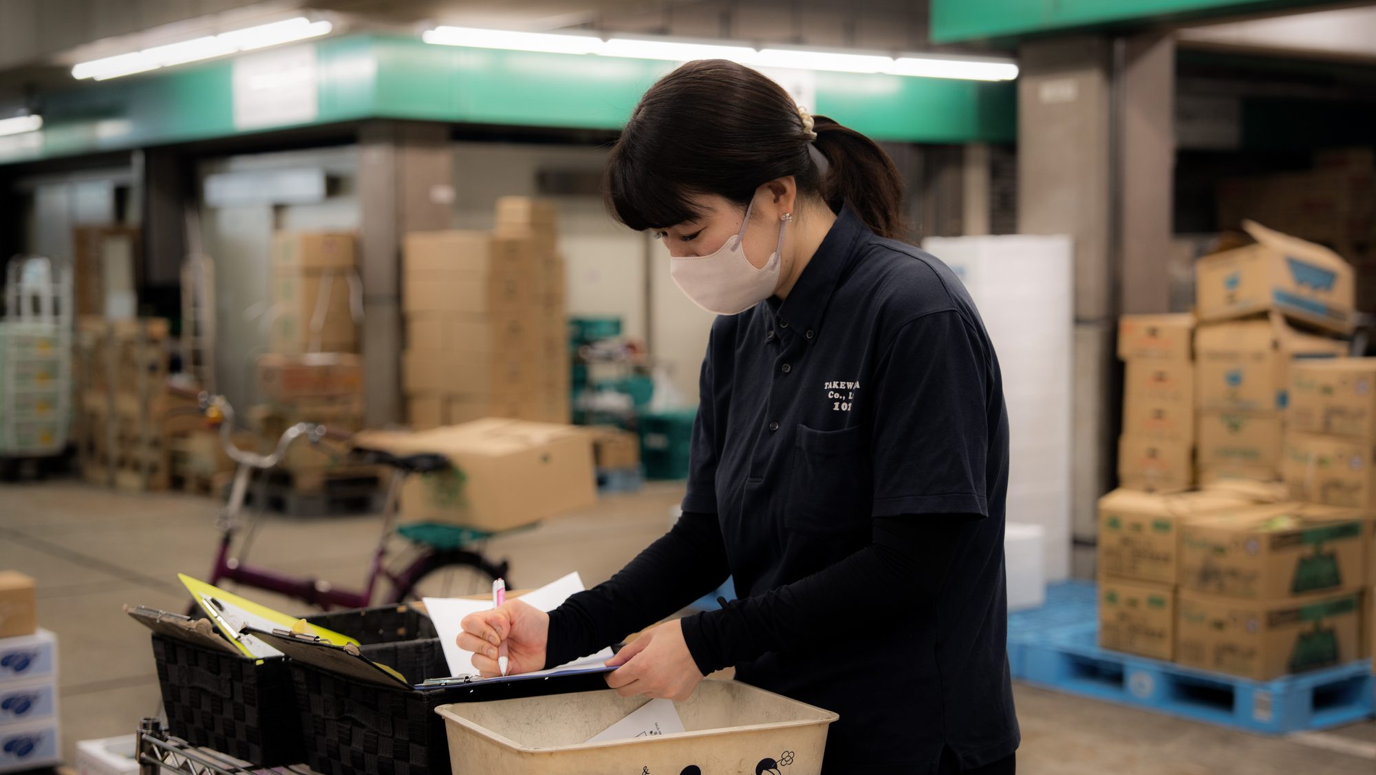 市場で伝票を確認する竹若の社員。