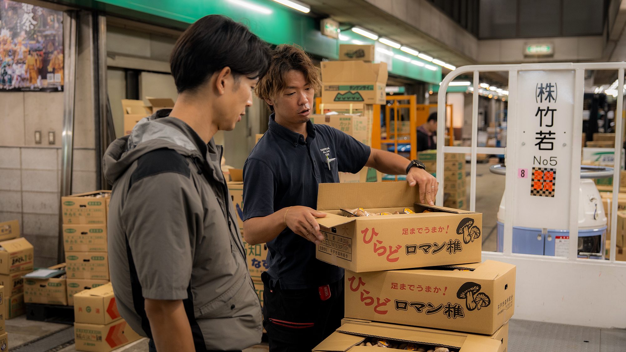 若手が品を手に取り見極め、先輩がそばで支える。
